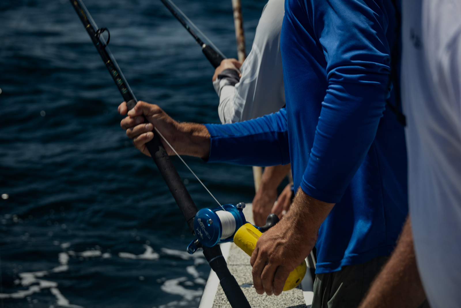 Person in blue shirt holding fishing rod.