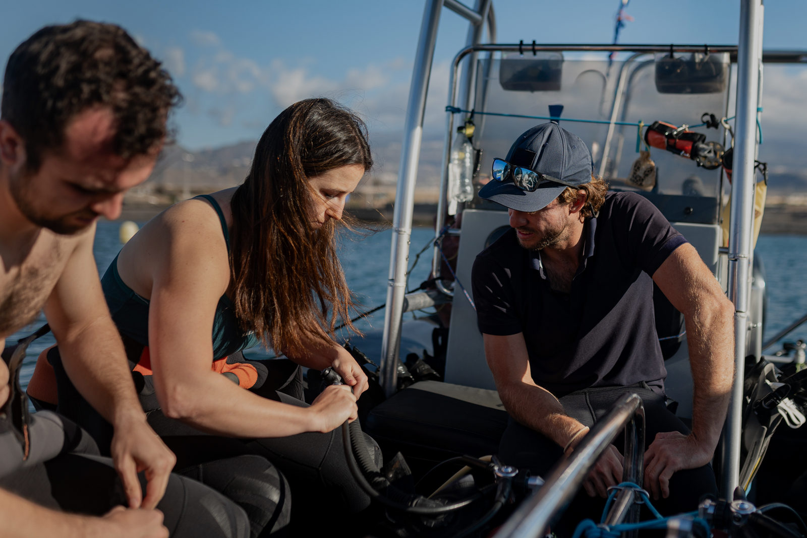 Three passengers on a boat interacting with equipment, showcasing what guests really remember from the experience.