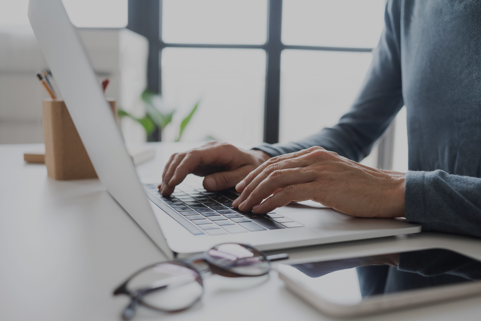 Person typing on a laptop while researching how long a captain’s license course takes.