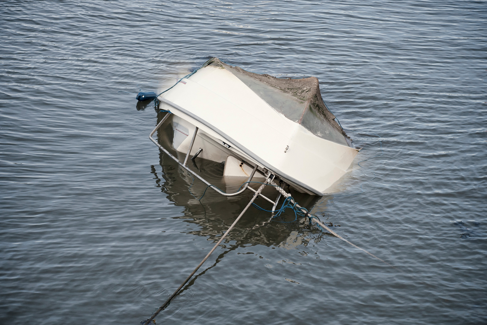 Small craft capsizing in a dark body of water.