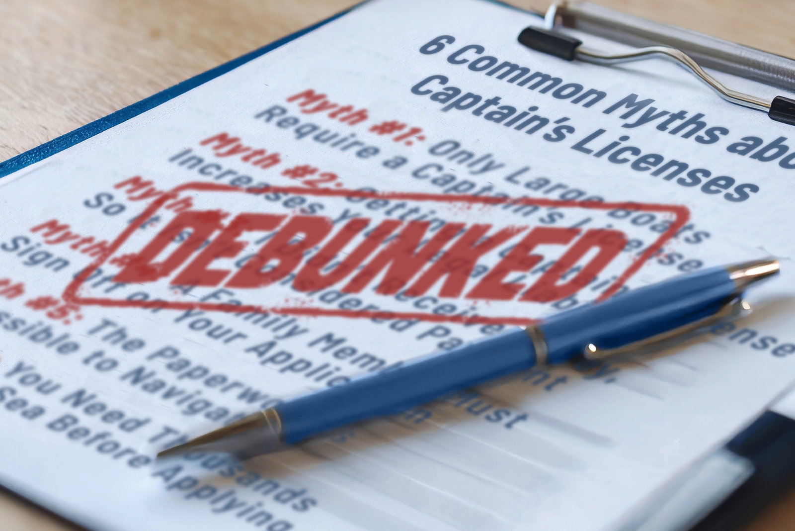 Clipboard with a pen and papers titled “6 Common Myths About Captain’s Licenses,” with “Debunked” in bold red text.