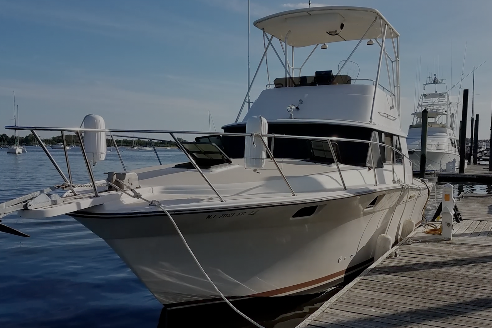 A white sport fishing boat or yacht docked at a marina.