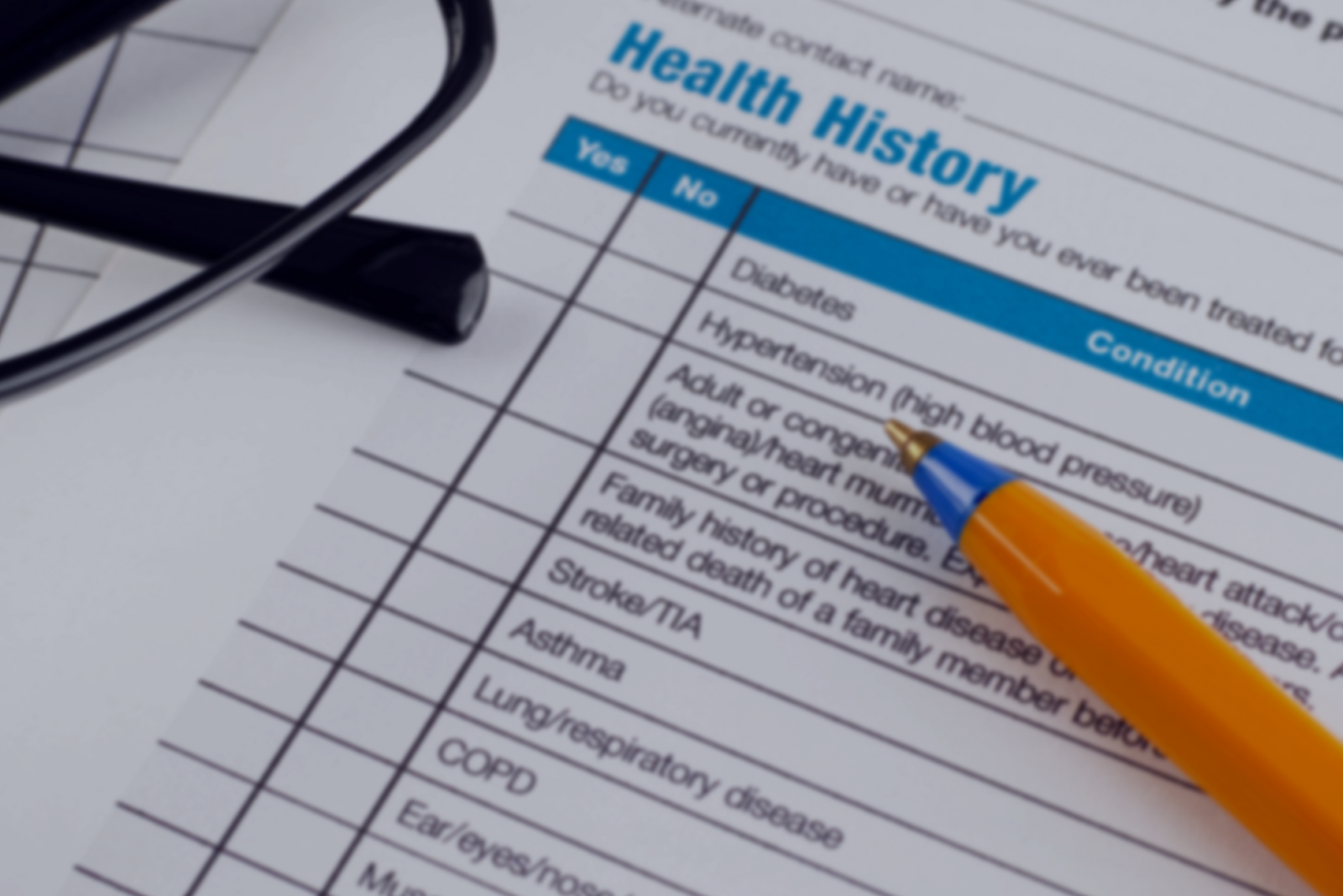 Health history form with glasses and pen listing conditions tied to captain’s license medical disqualifiers.