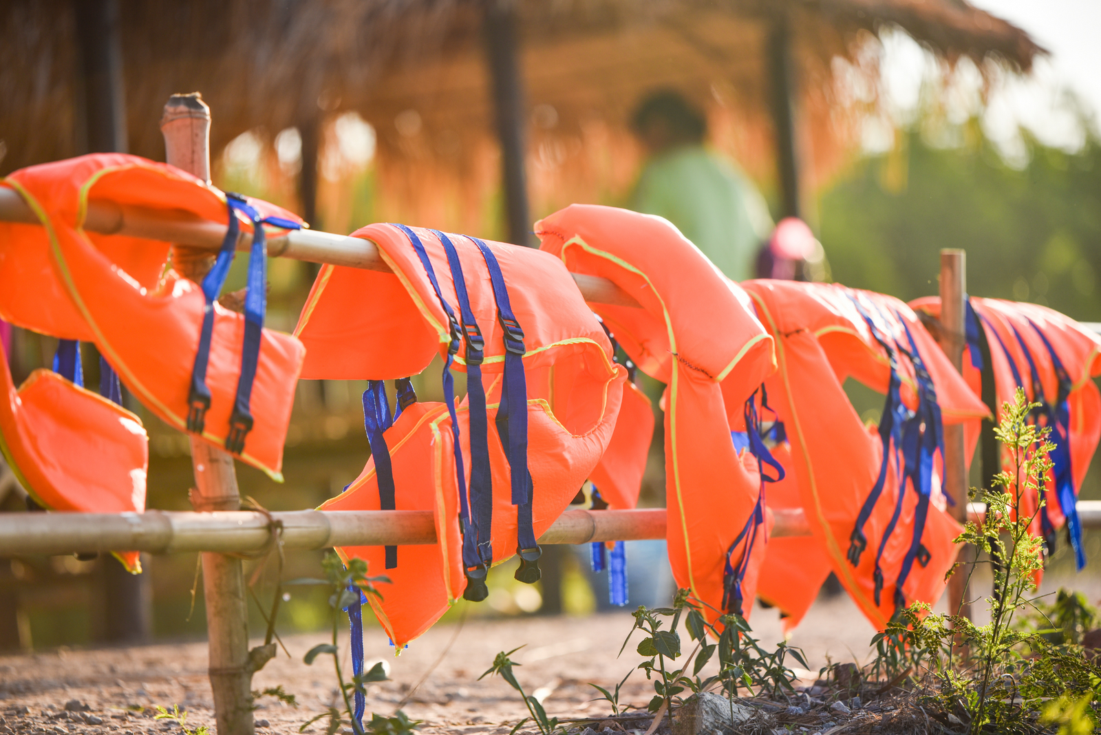 Life vests hanging on a railing for boat safety.