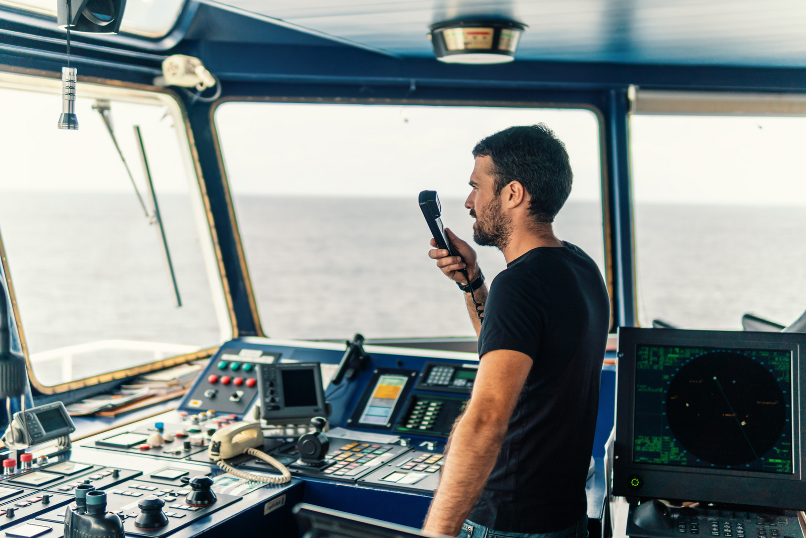 A young captain demonstrates how to call for help on a boat.