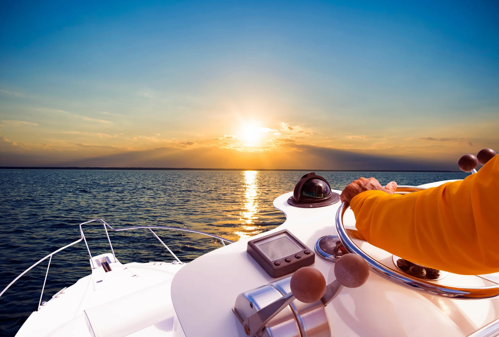 person driving boat at sunset