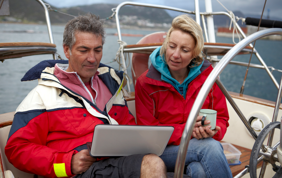 woman and man on boat looking at laptop