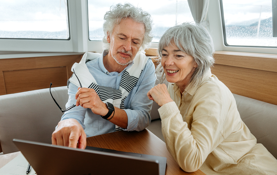 woman and man on boat looking at laptop