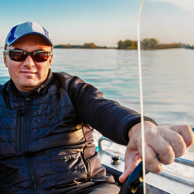 Person on a boat in the water with a scenic background