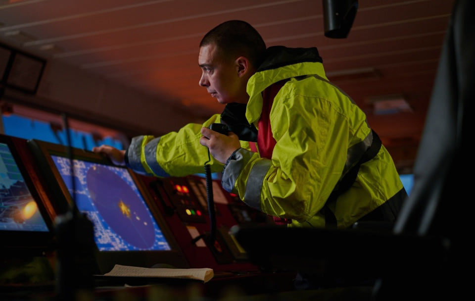 man looking at radar on boat