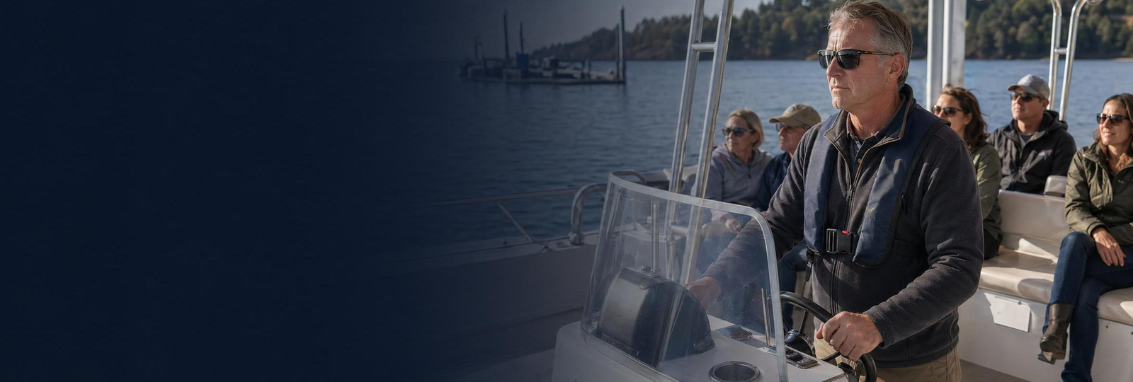 Man driving boat with passengers banner image