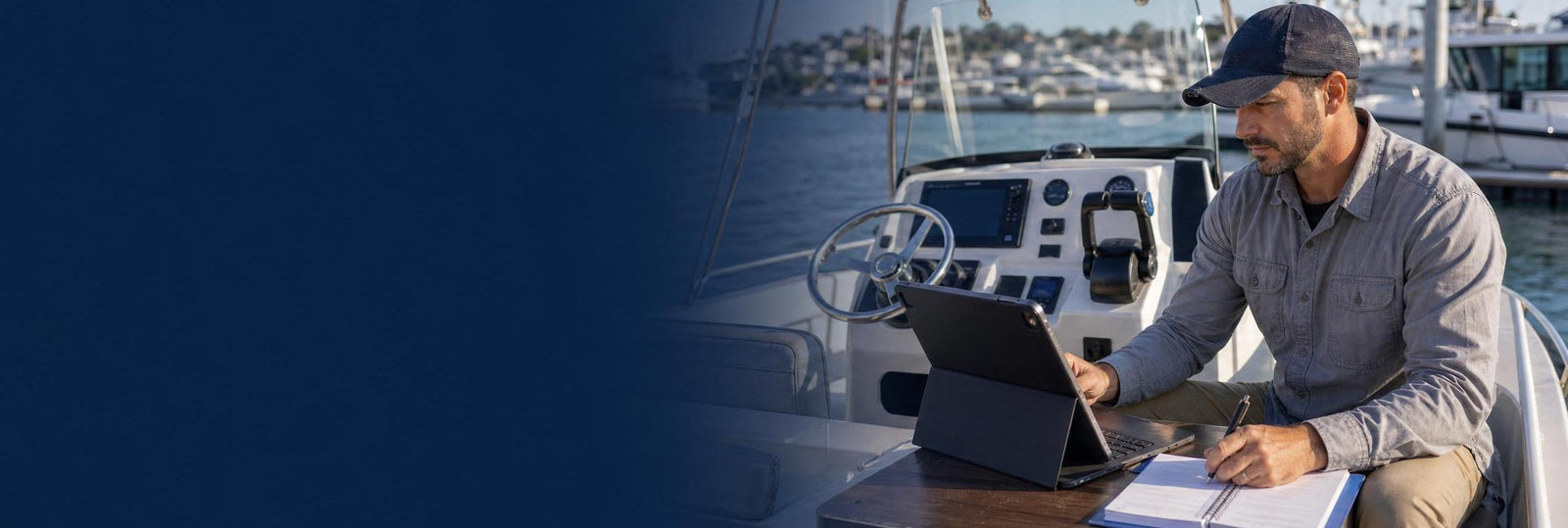 Man on boat working on lap top banner image
